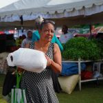 MUJER ADQUIERE PRODUCTO EN FERIA NAVIDAD DEL CAMBIO EN SANTO DOMINGO ESTE